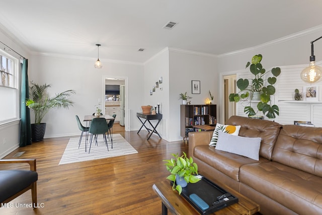 living room with wood-type flooring and ornamental molding