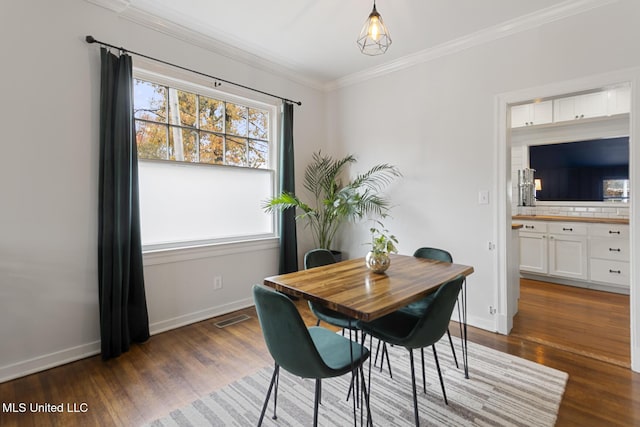 dining space with dark hardwood / wood-style floors and crown molding