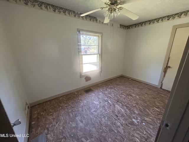 empty room with a textured ceiling and ceiling fan