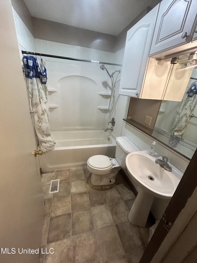 full bathroom featuring toilet, shower / bathtub combination with curtain, and sink