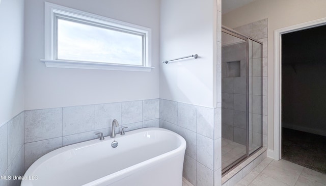 bathroom featuring tile patterned floors and separate shower and tub