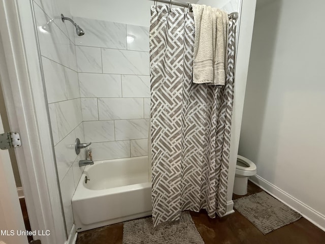 bathroom featuring shower / bathtub combination with curtain and toilet