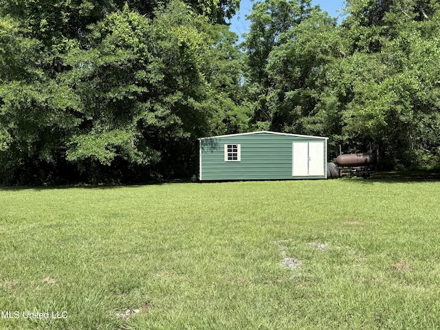 view of grassy yard with a shed and an outbuilding