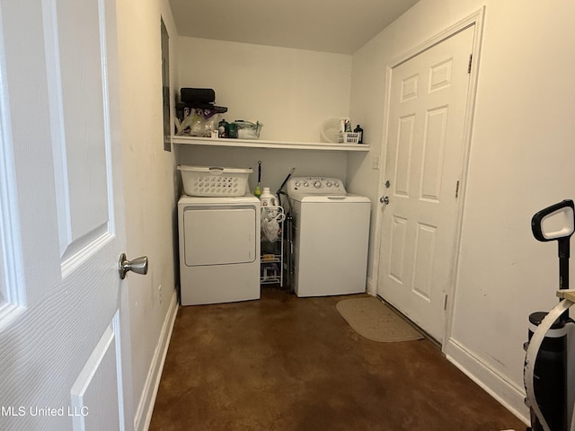 clothes washing area featuring washing machine and clothes dryer and baseboards