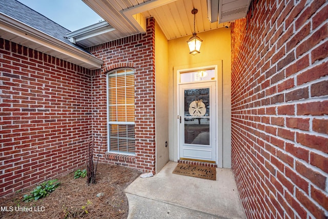 property entrance featuring brick siding and roof with shingles