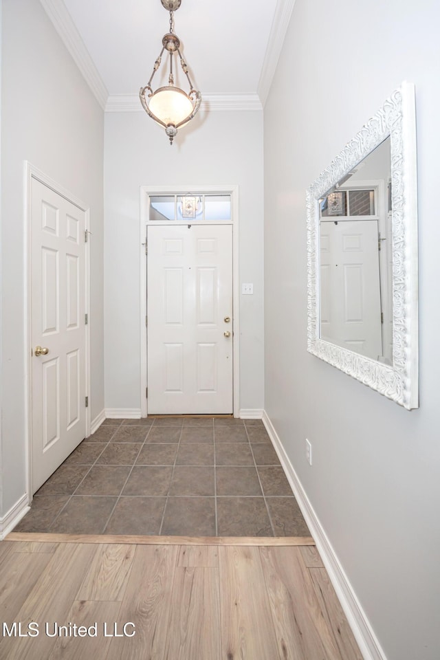 entryway with crown molding, baseboards, and wood finished floors