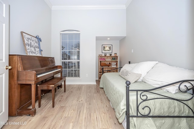 living area featuring baseboards, ornamental molding, and light wood finished floors