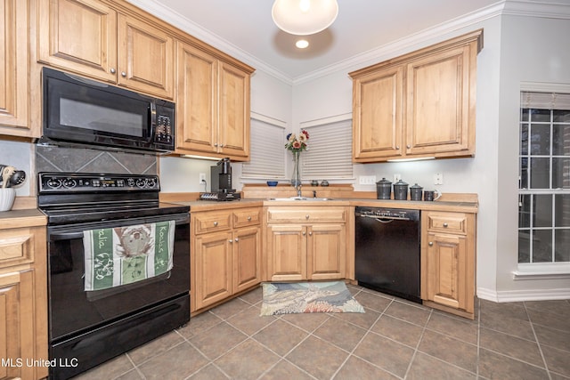 kitchen with a sink, black appliances, light countertops, and ornamental molding