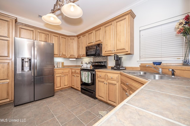 kitchen with a sink, tile patterned flooring, black appliances, light countertops, and crown molding