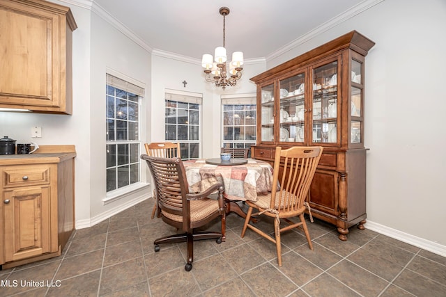 dining room with dark tile patterned floors, baseboards, a notable chandelier, and ornamental molding