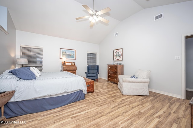 bedroom featuring baseboards, visible vents, light wood finished floors, and high vaulted ceiling