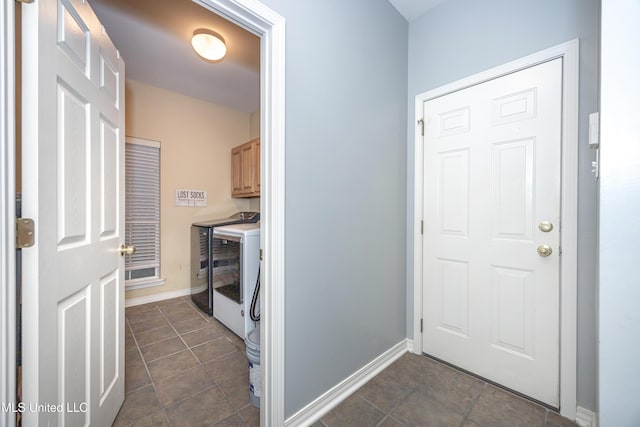 clothes washing area featuring washer and dryer, baseboards, and cabinet space