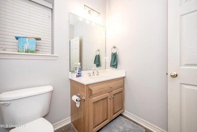 bathroom with vanity, toilet, and baseboards