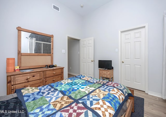 bedroom featuring visible vents, light wood-style flooring, and baseboards