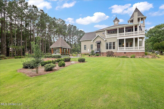 view of front of property featuring a gazebo, a balcony, and a front yard