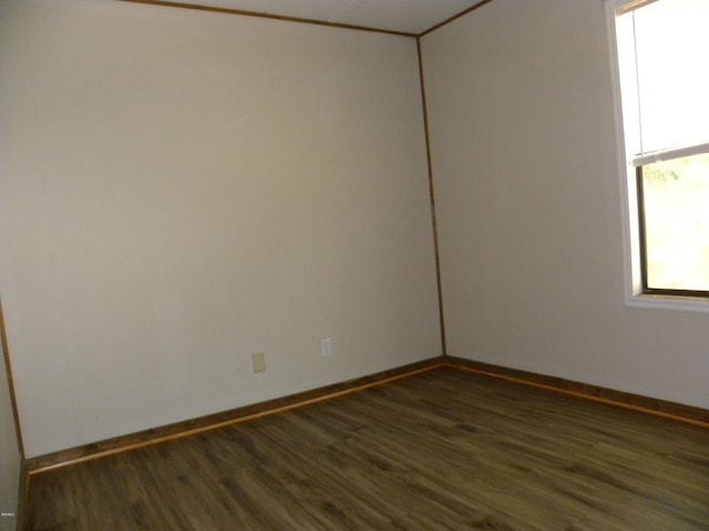 empty room with baseboards and wood finished floors