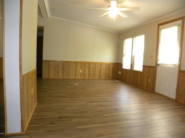 empty room with wood finished floors, a ceiling fan, a wainscoted wall, and ornamental molding