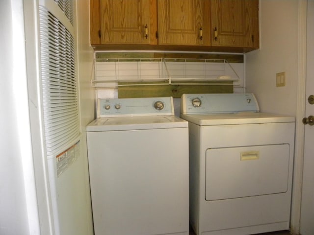 clothes washing area with a heating unit, cabinet space, and washer and dryer