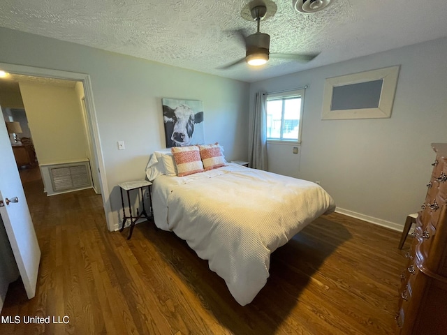 bedroom featuring a textured ceiling, dark hardwood / wood-style floors, and ceiling fan