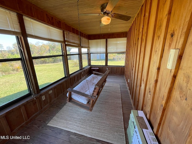 unfurnished sunroom featuring ceiling fan, a healthy amount of sunlight, and wood ceiling