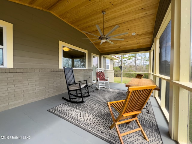 sunroom / solarium featuring lofted ceiling, ceiling fan, and wooden ceiling