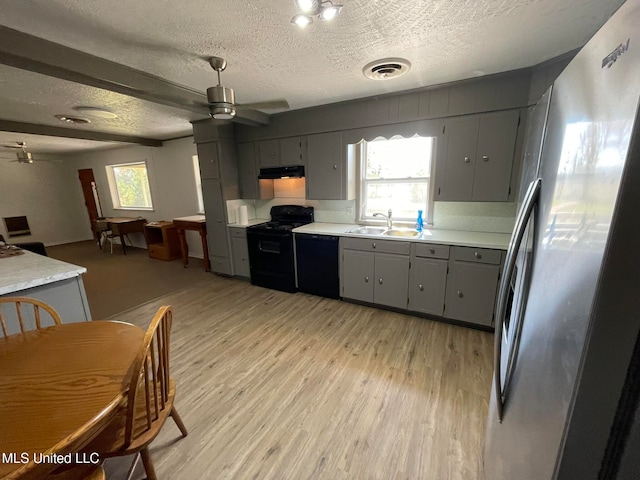 kitchen featuring gray cabinetry, a healthy amount of sunlight, black appliances, and sink