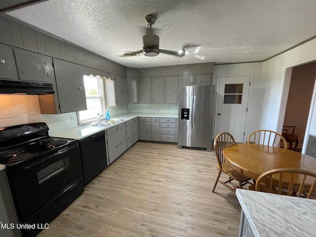 kitchen featuring exhaust hood, light hardwood / wood-style flooring, black appliances, gray cabinets, and ceiling fan