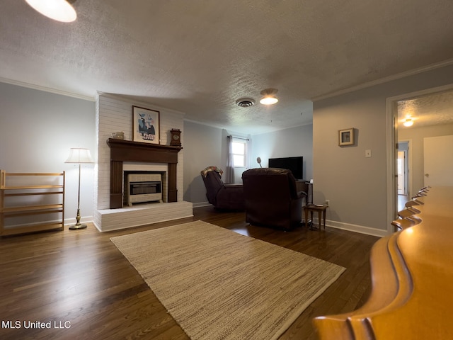 living room with a textured ceiling, a brick fireplace, and dark hardwood / wood-style floors