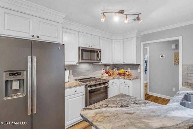 3007 Cross Point Cv, Brandon, MS 39042 - kitchen with appliances with stainless steel finishes, white cabinetry, light wood-type flooring, tasteful backsplash, and crown molding