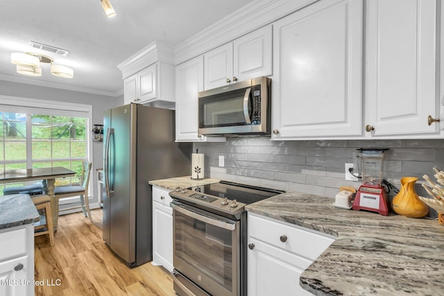 3007 Cross Point Cv, Brandon, MS 39042 - kitchen with stainless steel appliances, white cabinetry, ornamental molding, decorative backsplash, and light wood finished floors