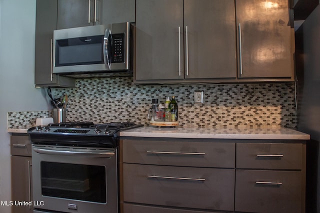 414 Spike Rdg, Canton, MS 39046 - kitchen featuring appliances with stainless steel finishes, light countertops, backsplash, and gray cabinetry
