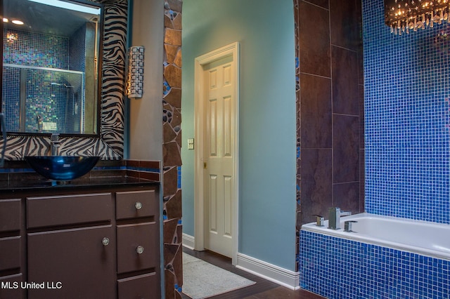 414 Spike Rdg, Canton, MS 39046 - full bathroom featuring tiled bath, vanity, a tile shower, baseboards, and wood finished floors
