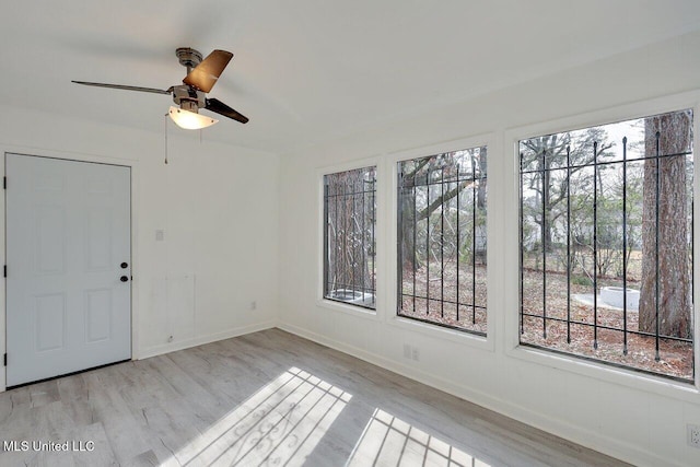 unfurnished room featuring ceiling fan, a wealth of natural light, and light hardwood / wood-style floors