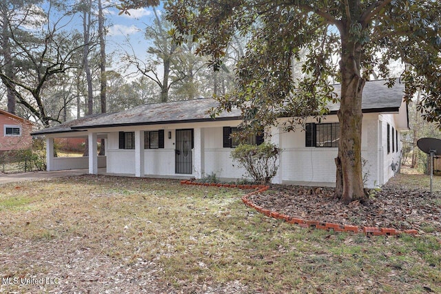 ranch-style home featuring a carport and a front lawn