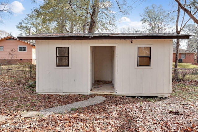 rear view of house featuring a storage shed