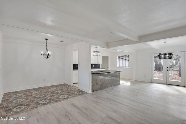 kitchen with beamed ceiling, pendant lighting, and white cabinets