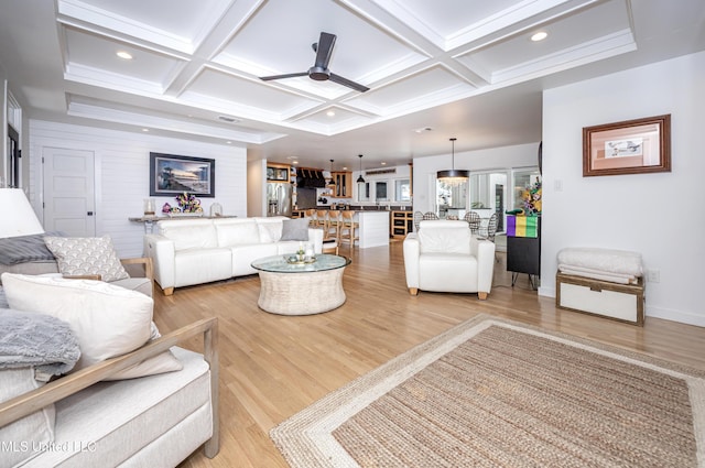 living area featuring coffered ceiling, ceiling fan, and light wood-style flooring