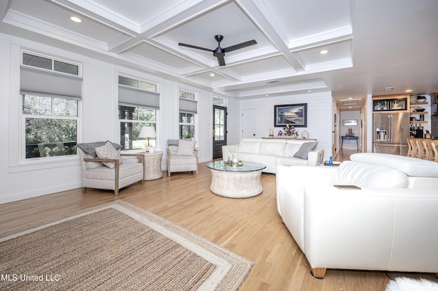 living room with light wood-type flooring, coffered ceiling, and beamed ceiling