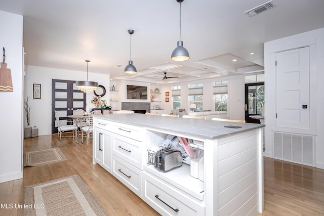 kitchen with open floor plan, visible vents, decorative light fixtures, and white cabinets