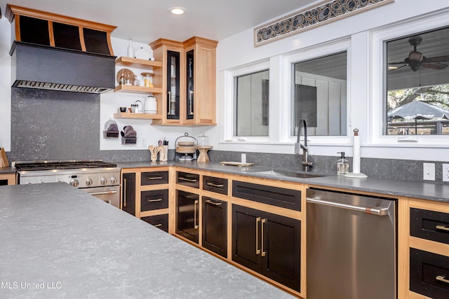 kitchen featuring dark countertops, custom exhaust hood, stainless steel appliances, open shelves, and a sink