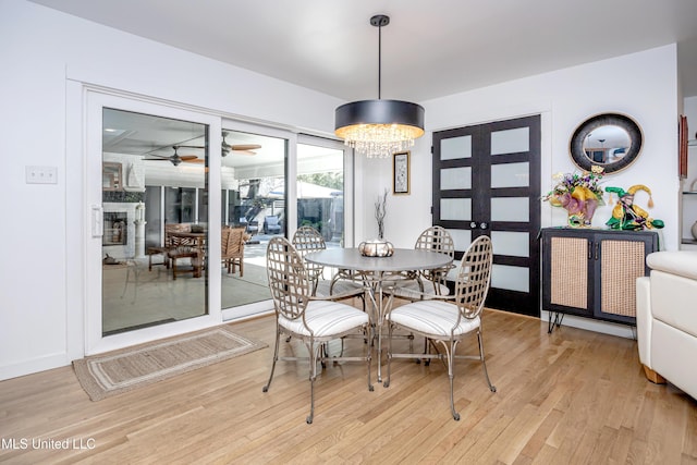 dining space with light wood-style floors and a chandelier