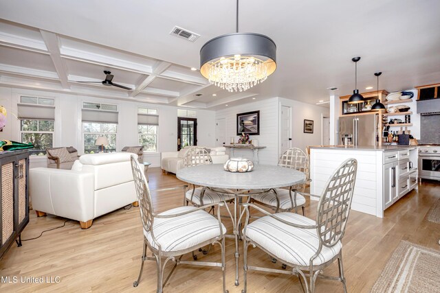 dining space featuring plenty of natural light, light wood finished floors, coffered ceiling, and visible vents