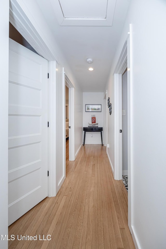 hallway featuring light wood-style floors and baseboards