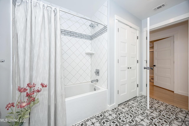 full bathroom with tile patterned flooring, visible vents, and shower / bath combo with shower curtain