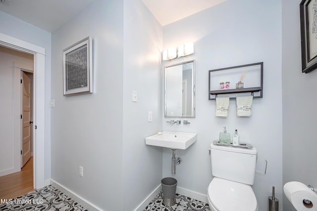 bathroom featuring toilet and baseboards