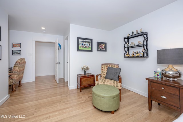 living area featuring light wood finished floors, baseboards, and recessed lighting