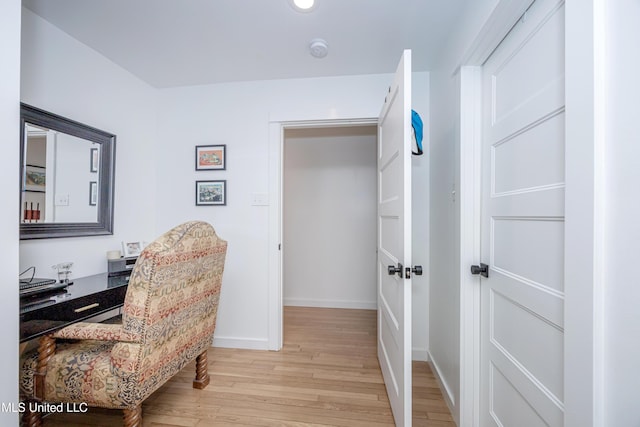 home office with baseboards and light wood finished floors