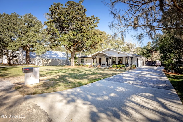 single story home with gravel driveway, covered porch, and a front lawn