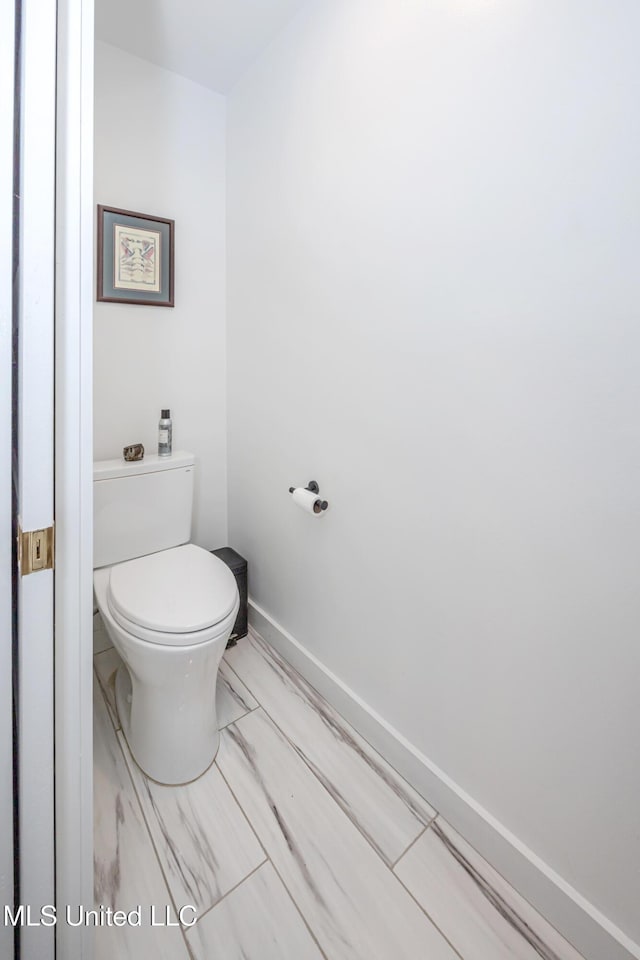 bathroom with toilet and baseboards