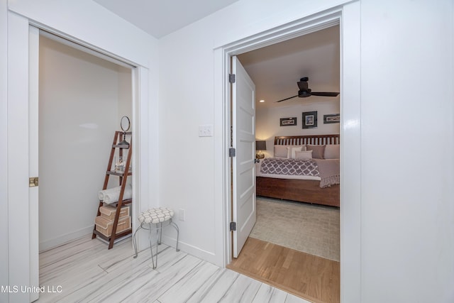 hallway featuring baseboards and light wood-style floors